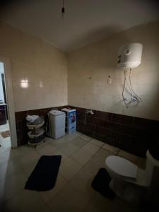 La salle de bains est pourvue de toilettes et d'une lumière sur le mur. dans l'établissement Home north cost, à Sīdī Sālim