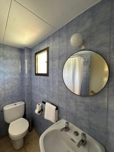 a bathroom with a sink and a toilet and a mirror at Hostal SolFina in Palafolls