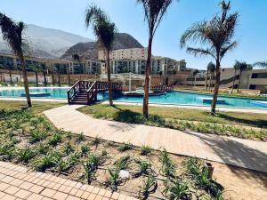 a swimming pool with palm trees and a resort at Ilmontegalala in Ain Sokhna