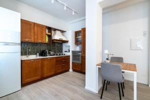 a kitchen with wooden cabinets and a table with a chair at Per le vie del Conero in Sirolo