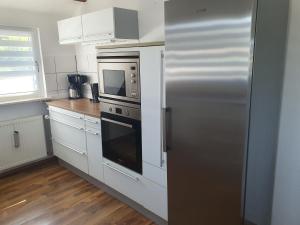 a kitchen with a stainless steel refrigerator and a microwave at Ferienwohnung Stephanshausen in Stephanshausen