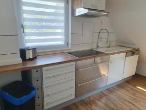 a kitchen with white cabinets and a sink and a window at Ferienwohnung Stephanshausen in Stephanshausen