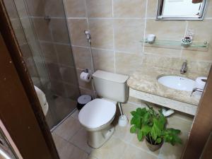 y baño con aseo y lavamanos. en Pousada Flor Dália, en Natal