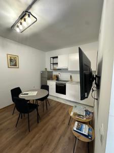 a living room with a table and chairs and a kitchen at Ronia apartment in Kaštela