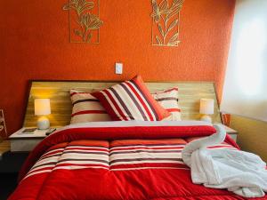 a bedroom with a bed with an orange wall at Hotel Los Diamantes in Orizaba