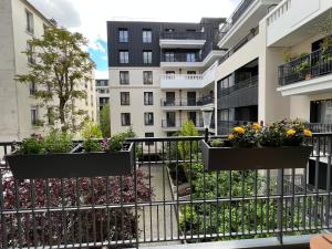 uma varanda de apartamento com flores numa cerca em Sérénité totale : appartement ensoleillé em Clichy