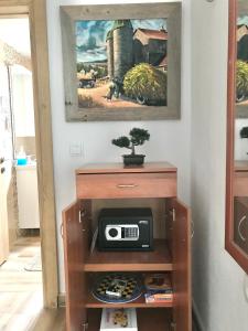 une armoire avec radio dans une pièce ornée d'une peinture dans l'établissement Villa Milka, à Utjeha-Bušat