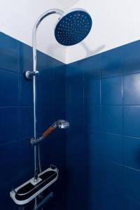 uma casa de banho azul com um chuveiro e uma parede de azulejos azuis em Cosy bleu proche arena JO (Bercy), RER C, métro 7 em Ivry-sur-Seine