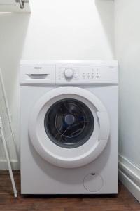 uma máquina de lavar roupa branca sentada num quarto em Cosy bleu proche arena JO (Bercy), RER C, métro 7 em Ivry-sur-Seine