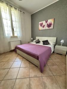 1 dormitorio con 1 cama grande con manta morada en Tenuta Pietro e Rosina, en Arnesano