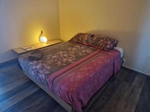 1 dormitorio con 1 cama con lámpara. en duplex moderne direct aéroport en Les Abymes