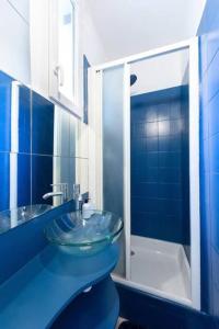 uma casa de banho azul com um lavatório de vidro e um chuveiro em Cosy bleu proche arena JO (Bercy), RER C, métro 7 em Ivry-sur-Seine