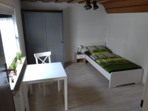 ein Schlafzimmer mit einem Bett, einem Tisch und einem Stuhl in der Unterkunft Gästezimmer M. Schubert in Oberelbert