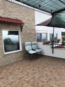 a patio with a chair and an umbrella at Villa Milka in Utjeha