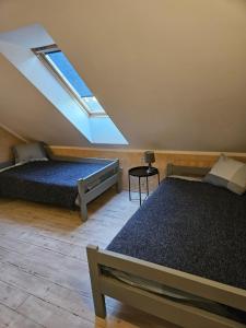 a attic bedroom with two beds and a skylight at Ķērpji in Ulmale