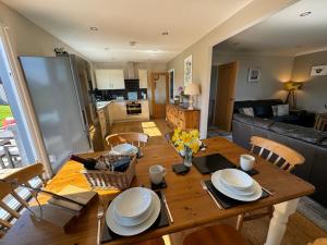 Drumhead Cottage Finzean, Banchory Aberdeenshire Self Catering with Hot Tub في Finzean: مطبخ وغرفة طعام مع طاولة خشبية