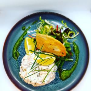 eine blaue Platte mit Fisch und Gemüse in der Unterkunft Hôtel-Restaurant La Mascotte in La Baule