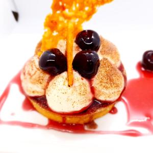 拉波勒的住宿－Hôtel-Restaurant La Mascotte，盘子里装水果和糖浆的煎饼