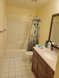 een badkamer met een bad, een toilet en een wastafel bij 1 bedroom in a cheerful home with indoor fire place in Fort Washington