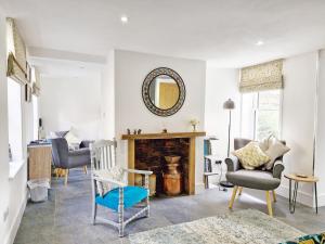 een woonkamer met een open haard, stoelen en een spiegel bij Four Priory Road, Chichester in Chichester