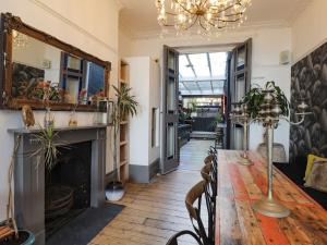 HollingtonにあるZanzibar Beach Houseのダイニングルーム(暖炉、テーブル、椅子付)