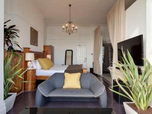 HollingtonにあるZanzibar Beach Houseのベッドと椅子とソファのある寝室