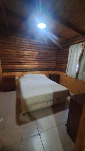 um quarto com uma cama com uma luz no tecto em Los Tronquitos em Santa Rosa de Calamuchita