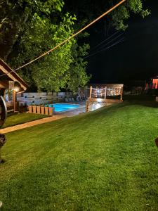 a yard at night with a playground and a pool at Rtanjska kućica in Boljevac