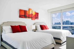 邁阿密的住宿－Beautiful apartment Miami, FL，带窗户的客房内的两张床和红色枕头