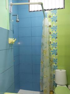 y baño con cortina de ducha y aseo. en Hospedaje Educol, en Moyobamba