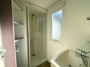 a bathroom with a shower and a tub and a window at Camping Dolce Vita in Calvi