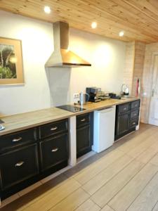 a kitchen with black cabinets and a stove at Ķērpji in Ulmale