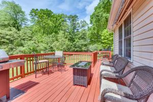 a wooden deck with chairs and tables on a house at Chatham Getaway with Fireplace, Deck and Gas Grill! in Chatham