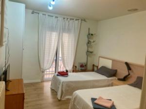 a bedroom with two beds and a large window at Apartamento San Gregorio in Pamplona