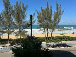 uma vista para uma praia com árvores e o oceano em Apto com VISTA ESPETACULAR a BEIRA MAR no Pecado - Wi Fi 200 mb - 2 Quartos - Garagem - TV Smart - Piscina - Sauna - Ar condicionado - Portaria 24h - Churrasqueira - Cozinha equipada em Macaé