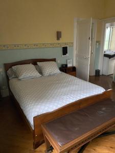 a bedroom with a large bed with white sheets at maison de maitre in Fleury-sur-Andelle