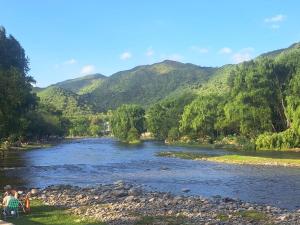 um rio com um grupo de pessoas sentadas ao lado dele em Los Tronquitos em Santa Rosa de Calamuchita