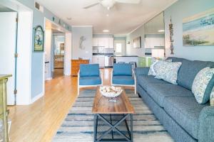 カロライナビーチにある2nd Row Condo with Oceanviews - Haven at TideWindsのソファとテーブルのあるリビングルーム