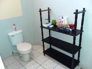 ein Badezimmer mit einem schwarzen Regal neben einem WC in der Unterkunft See Belize TRANQUIL Sea View Studio with Balcony, Infinity Pool & Overwater Deck in Belize City