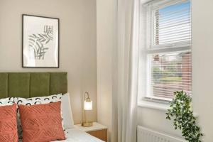 a bedroom with a bed with red pillows and a window at Cosy & Modern Property in London - Sleeps up to 6 in London