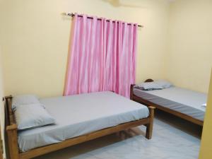 Ένα ή περισσότερα κρεβάτια σε δωμάτιο στο Venu's Homestay