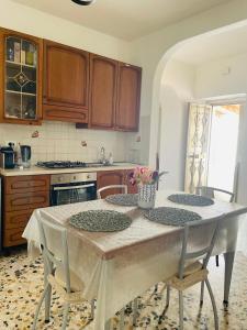 una cucina con tavolo con 2 sedie e una cucina con piano cottura di La Casetta del Borgo Antico a Campomarino