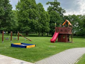 un parque infantil con tobogán y estructura de juegos en Klaudia's Hotel & Restaurant at Golf Resort, Bač Šamorín en Báč