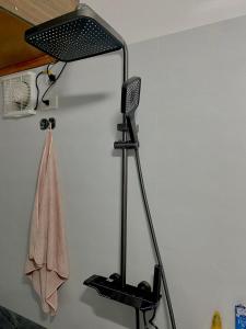 a black lamp on a wall with a towel at Ngất Ngây Homestay in Sầm Sơn