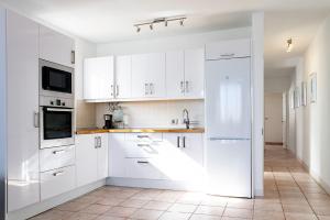 a white kitchen with white cabinets and a sink at Puerto del Carmen Las caracolas Acogedor espacioso y luminoso apartamento cerca del mar in Puerto del Carmen