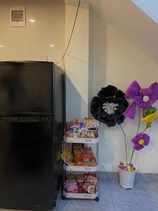 a black refrigerator freezer sitting next to a shelf of food at Ngất Ngây Homestay in Sầm Sơn