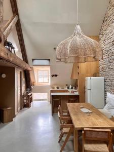 une cuisine avec une table et un réfrigérateur dans l'établissement Le Toit des Hospices : HyperCentre/Vue/Clim, à Beaune