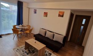 a living room with a couch and a table at Ap CALAS , No2 2A Parter, Free Parking in Râşnov