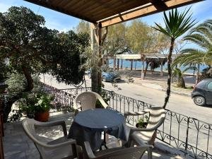 a table and chairs on a balcony with a view of the ocean at Nikos Holidays Apartment 1 in Petra