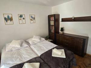 a bedroom with a large white bed with two pillows at Apartament Lawenda in Stary Sącz